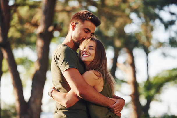 Happy together. Embracing each other. Beautiful young couple have a good time in the forest at daytime. - Fotoğraf, Görsel