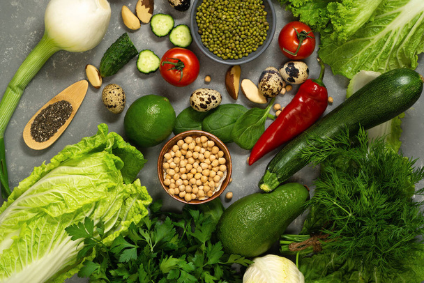 Свежие здоровые овощи с авокадо, горох, орехи и травы для здорового питания. Сбалансированное питание из клетчатки и растительных белков - Фото, изображение