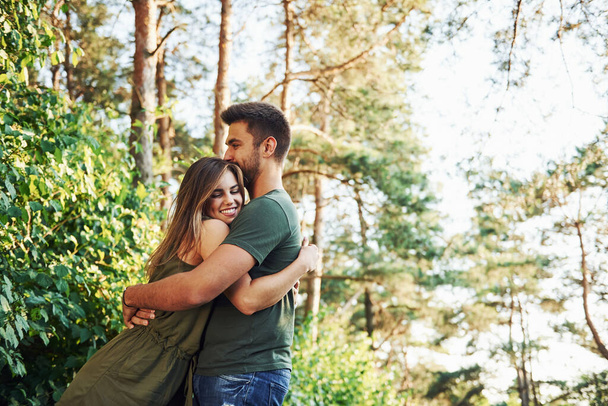 Beautiful young couple have a good time in the forest at daytime. - Fotografie, Obrázek