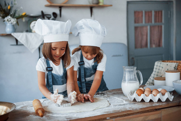 Family kids in white chef uniform preparing food on the kitchen. - Фото, изображение