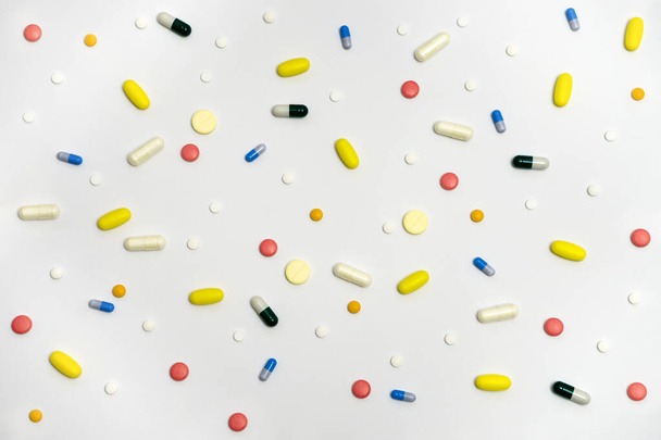 Varietà di farmaci in capsule e pillole di diversi colori su uno sfondo bianco - Foto, immagini