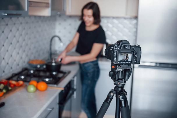 Focused on the camera. Girl in the modern kitchen at home at her weekend time in the morning. - Φωτογραφία, εικόνα
