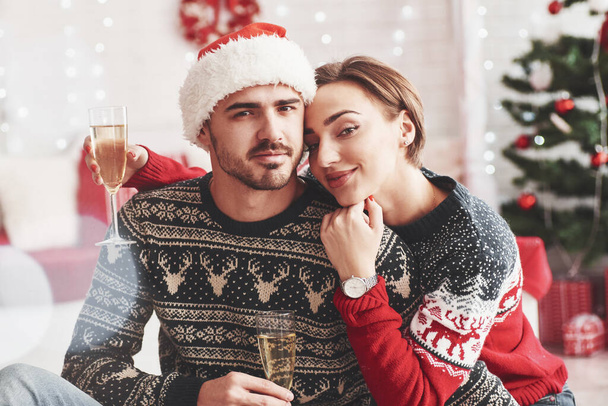 Together at holidays. Happy young people sits in the room with christmas decorations. - 写真・画像