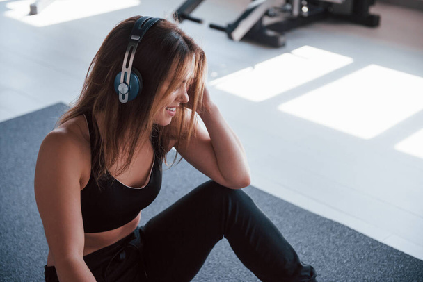 Music is life. Photo of gorgeous blonde woman in the gym at her weekend time. - Photo, image