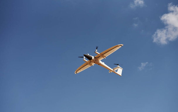 Modern small remote controlled white colored plane flying up in the sky. - Foto, Bild