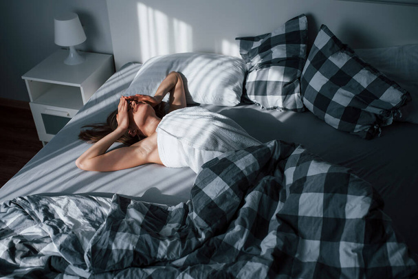 Waking up with pleasure. Pretty young woman lying on the bed at morning time in her room. - Fotó, kép