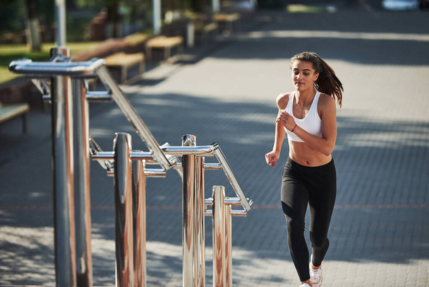 Sportive woman have fitness day and running in the city at daytime. Near the railings. - Foto, Imagem