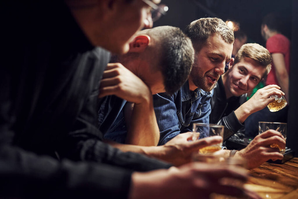 Guy feels awful. Friends resting in the pub with alcohol in hands. Having conversation. - Photo, Image