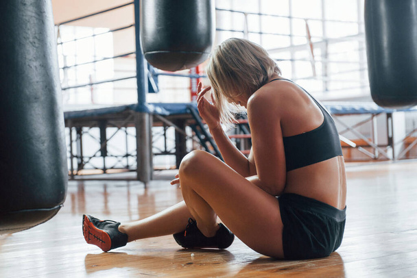 Sits on the floor after training. Tired after workout. Having rest in the gym for box sport training. - Fotó, kép