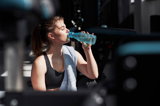 Remember to always bring water with you. Photo of gorgeous blonde woman in the gym at her weekend time. - Fotoğraf, Görsel