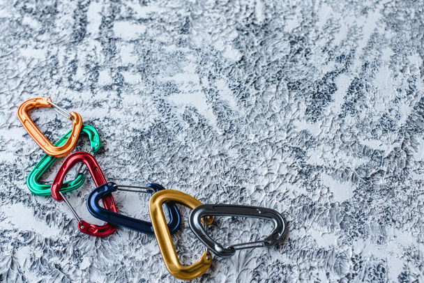 Risky extreme sports. Isolated photo of climbing equipment. Part of carabiner lying on the white and grey colored surface. - 写真・画像