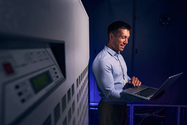 Cheerful male employee working in data center - Photo, image
