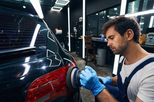Polishing of auto taillight in repair workshop - Photo, image