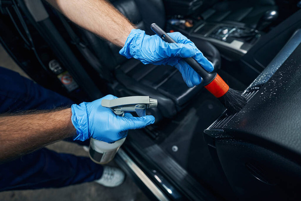 Mechanic cleaning car air vent with brush and spray bottle - Φωτογραφία, εικόνα
