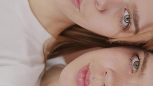 Portret pionowy z ekstremalnym zbliżeniem na twarzach pięknych bliźniaczek z zielonymi oczami - Materiał filmowy, wideo