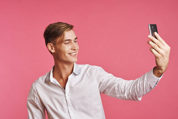 handsome man technology communication emotions pink background - Valokuva, kuva