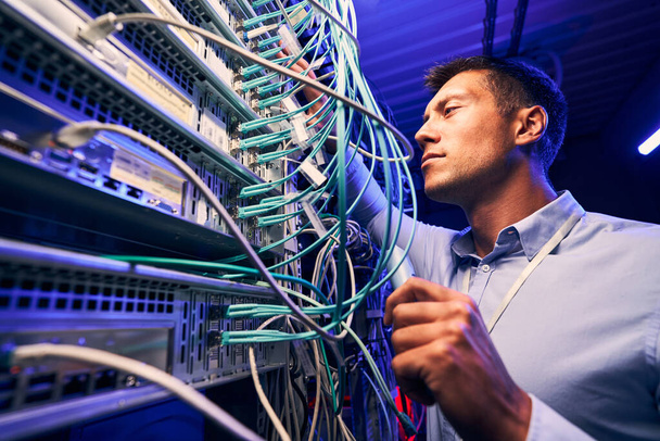 Ingenieur testet Kabelverbindungen auf Netzwerkserver - Foto, Bild