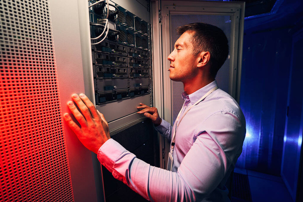Serious concentrated IT technician inspecting hardware equipment - Photo, Image