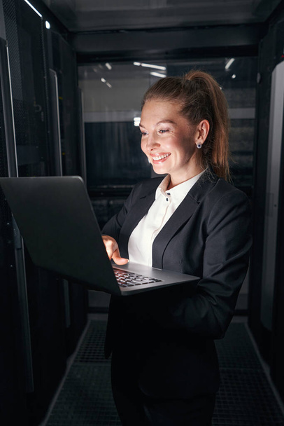Professionelle junge Frau arbeitet im Serverschrank - Foto, Bild