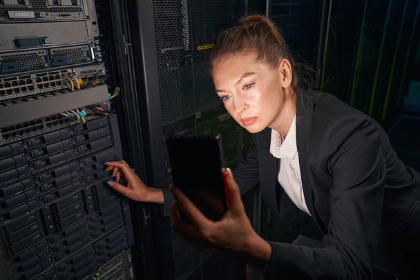 Young woman working on data center using cellphone - Foto, Bild