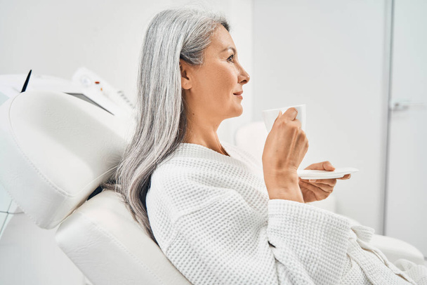 Attractive female person sitting on dermatology chair - Fotó, kép