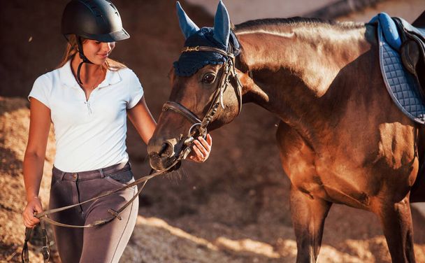 Cheerful mood. Horsewoman in uniform and black protective helmet with her horse. - Φωτογραφία, εικόνα