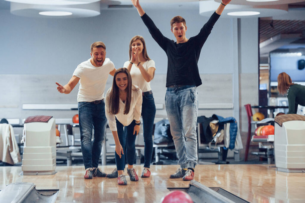 You can made the strike. Young cheerful friends have fun in bowling club at their weekends. - Foto, Bild