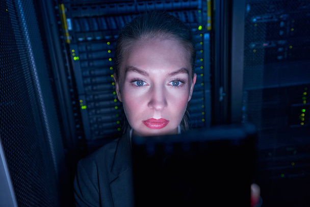 Porträt einer jungen Frau, die im Serverraum arbeitet - Foto, Bild