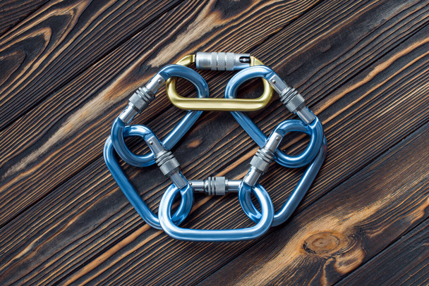 For the leisure activities. Isolated photo of climbing equipment. Parts of carabiners lying on the wooden table. - Foto, immagini