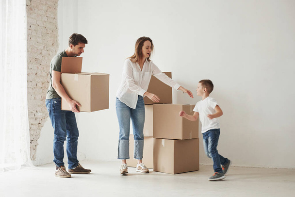 Running kid. Family have removal into new house. Unpacking moving boxes. - Φωτογραφία, εικόνα