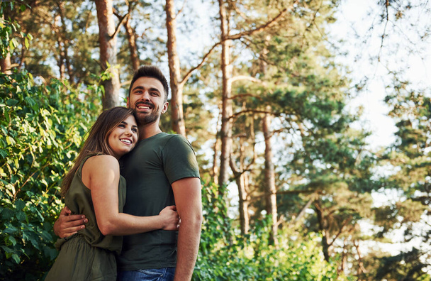 Beautiful young couple have a good time in the forest at daytime. - Fotoğraf, Görsel