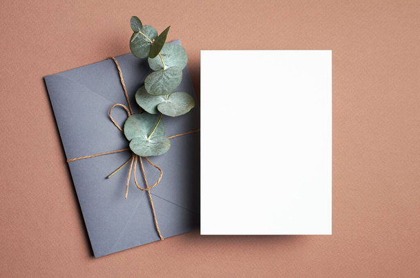 Wedding invitation or greeting card mockup with envelope and eucalyptus twig decoration. - Fotografie, Obrázek