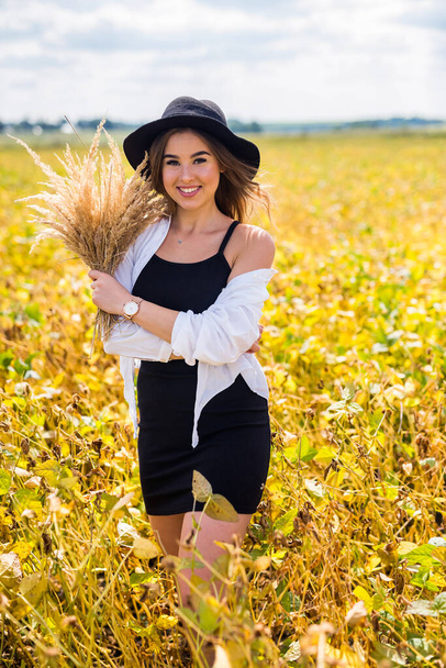 красивая молодая девушка наслаждается летним отпуском, гуляя по сельскому полю, понятием счастья здоровья - Фото, изображение