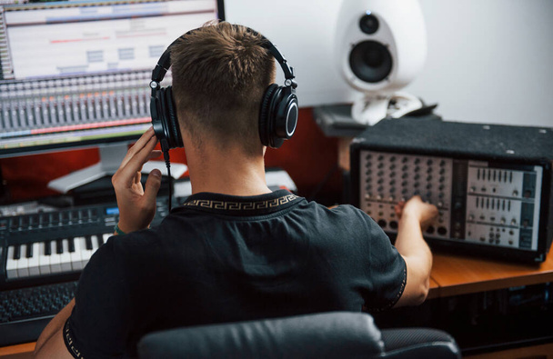 Sound engineer in headphones working and mixing music indoors in the studio. - 写真・画像