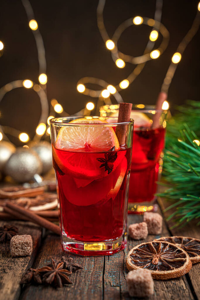 Mulled wine in the evening lighting on a festive background. Vertical view, close-up. Selective focus. - 写真・画像