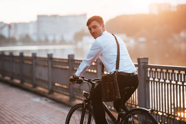 Feeling good. Businessman in formal clothes with black bicycle is in the city. - Foto, Imagem