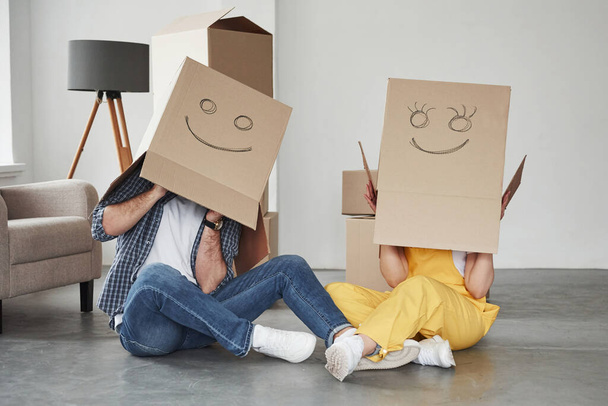 Looks cute. Happy couple together in their new house. Conception of moving. - Фото, изображение