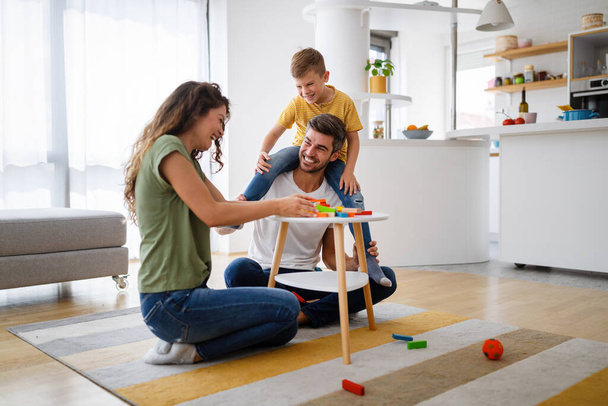 Happy family with parents and son playing with colorful blocks at home - Φωτογραφία, εικόνα