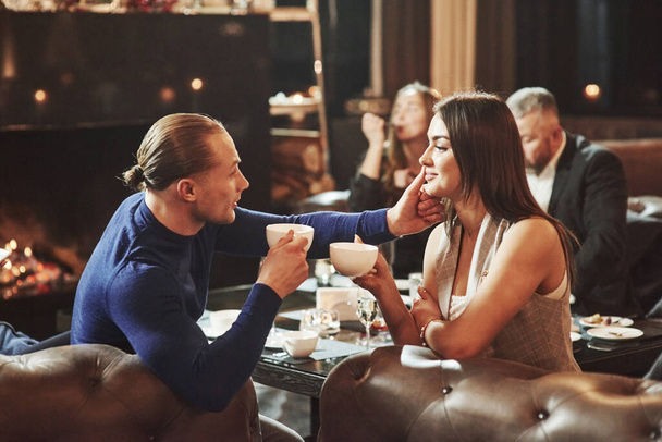 Touching the face. Beautiful couple. Family friends having nice time in beautiful luxury modern restaurant. - Valokuva, kuva