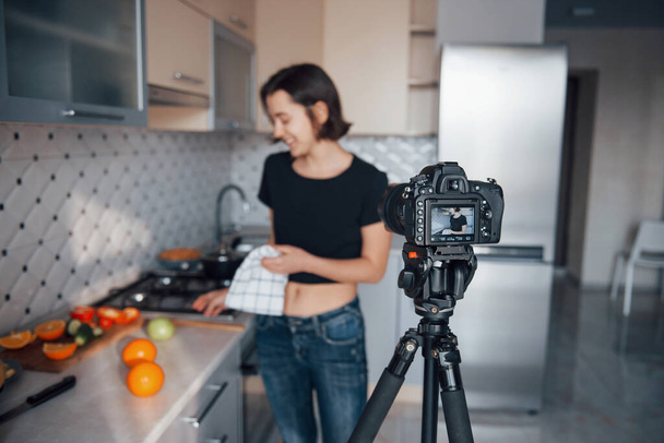 Camera in front of woman. Girl in the modern kitchen at home at her weekend time in the morning. - Fotoğraf, Görsel
