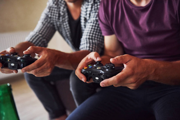 Group of friends have fun playing console game indoors at living room. - 写真・画像