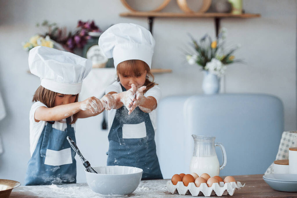 Family kids in white chef uniform preparing food on the kitchen. - Foto, afbeelding