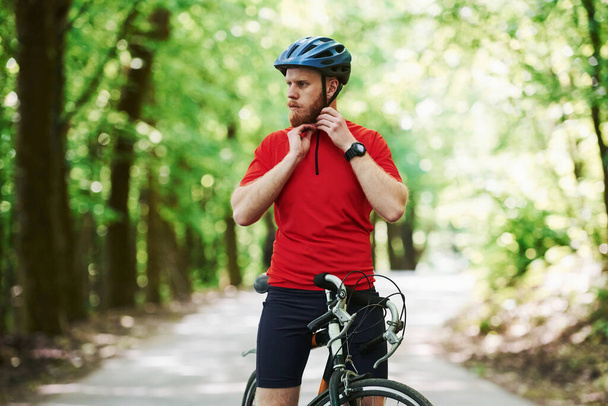 À la campagne. Cycliste sur un vélo est sur la route asphaltée dans la forêt à la journée ensoleillée. - Photo, image