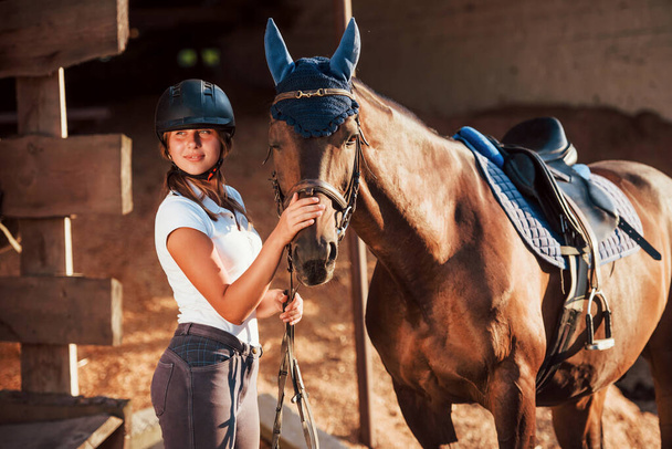 Animal is in blue clothes. Horsewoman in uniform and black protective helmet with her horse. - Φωτογραφία, εικόνα