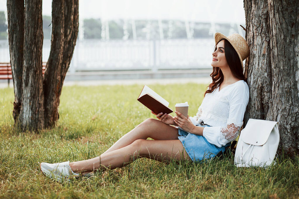 Attractive smiling girl. Young woman have weekend and sits in the park at daytime. - 写真・画像