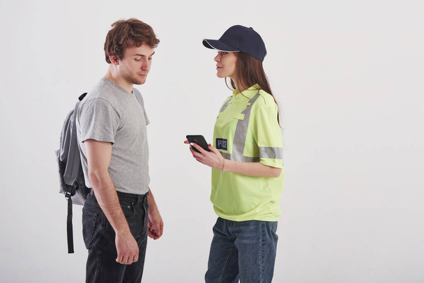 Modern people. Pretty woman in green police uniform have conversation with male student against white background in the studio. - Foto, Imagen