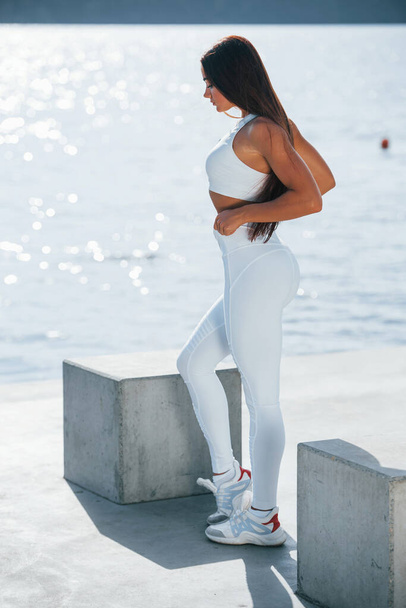 Posing for the camera. Young fitness woman with slim body type is outdoors. - Foto, Bild