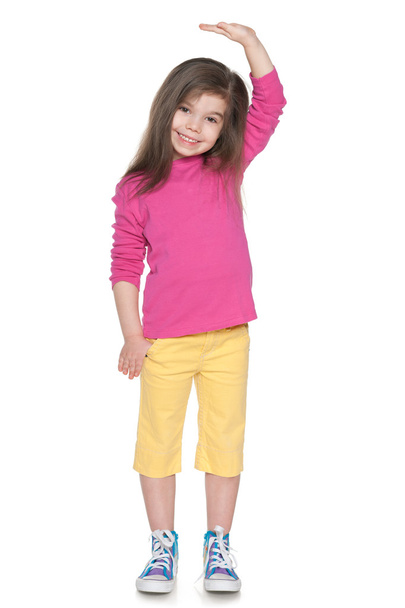 Smiling little girl showing her height - Foto, afbeelding