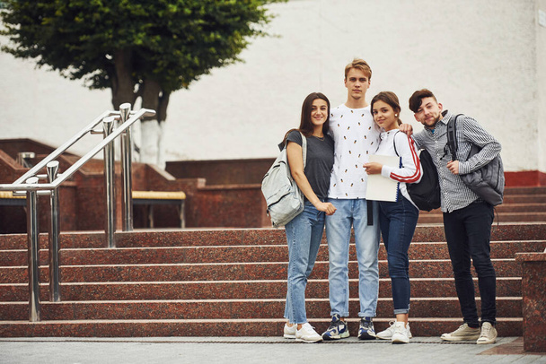 Posing for a camera. Group of young students in casual clothes near university at daytime. - Photo, Image