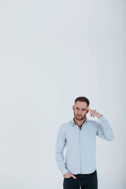 Always use your mind. Man in official clothes stands against white background in the studio. - Fotó, kép